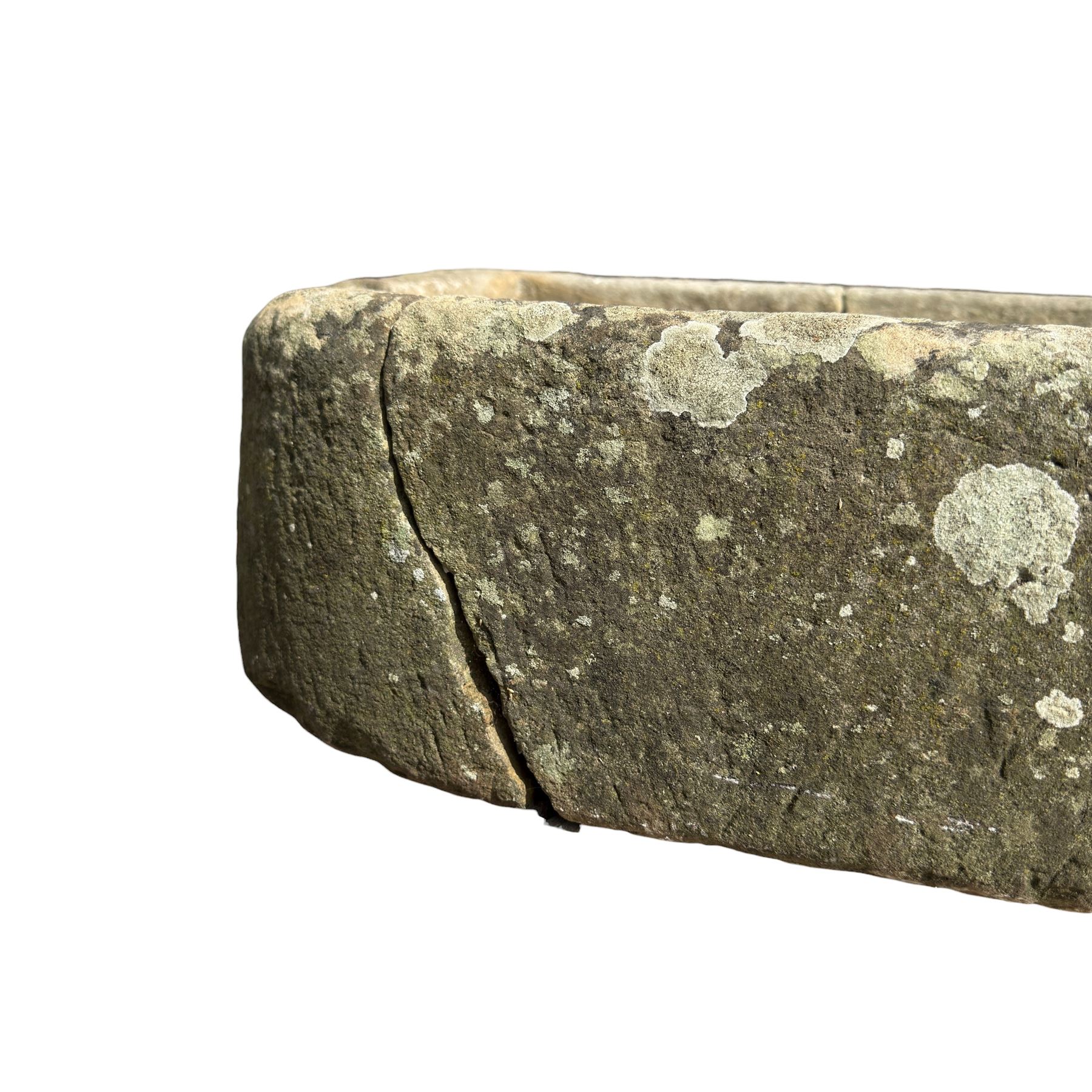 19th century hewn sandstone trough of D shaped form, in weathered finish