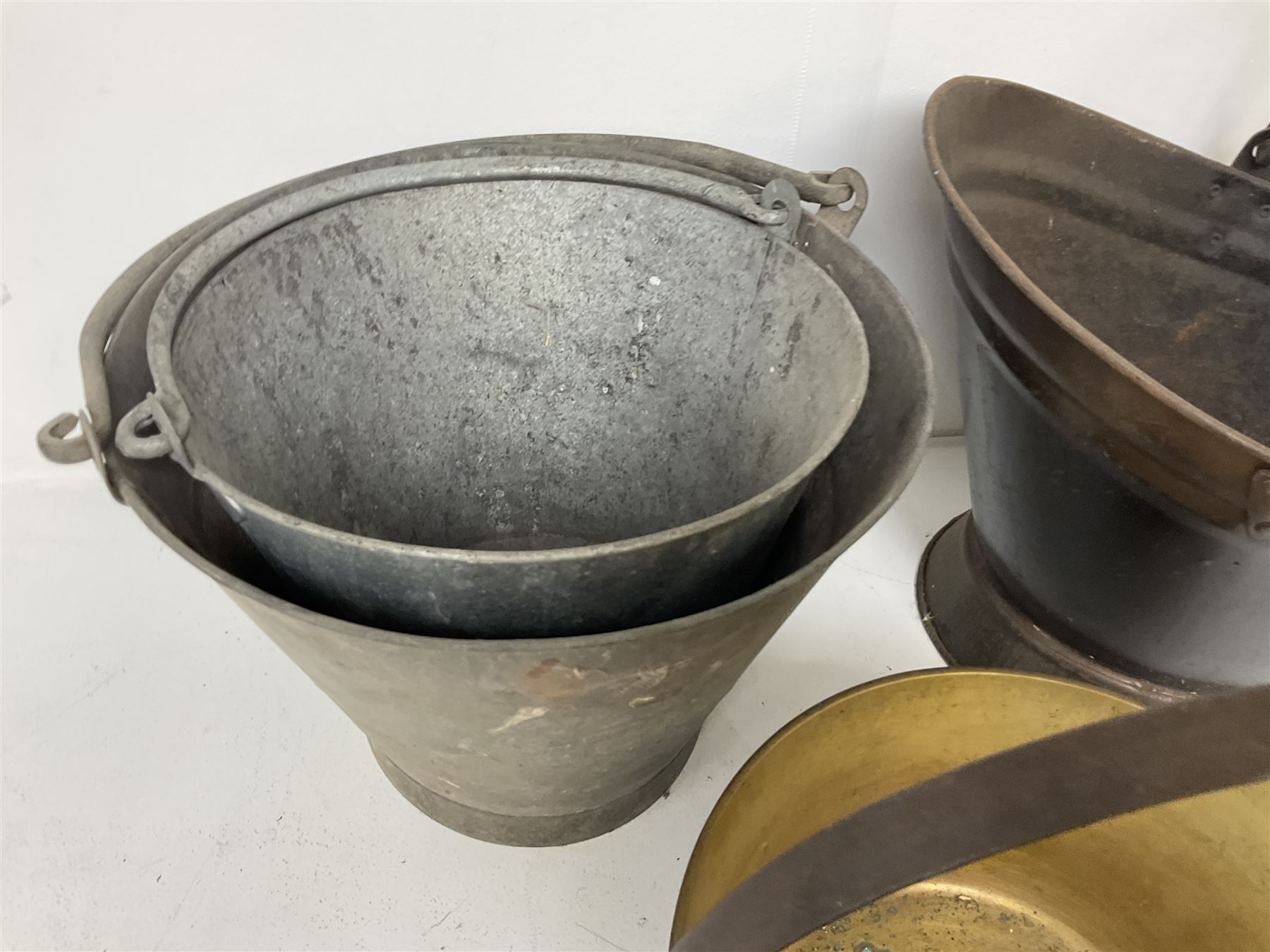 Two vintage galvanised watering cans, three galvanised buckets and a brass jam pan