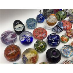 Collection of glass paperweights to include probably Clichy example of rose cane design upon marble base, art glass examples of various sizes and shapes, captured bubble and millefiori designs etc with various makers marks
