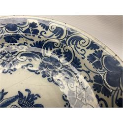 Early 18th century Delft marriage plate, of circular form with dished centre, the centre inscribed and dated 'Thomas and Elizabeth Kockerill Bridlington Key 1715' within a crowned C scroll cartouche, flanked by demi-griffins, above a putto head and tassels, within a wide foliate border, D34cm
