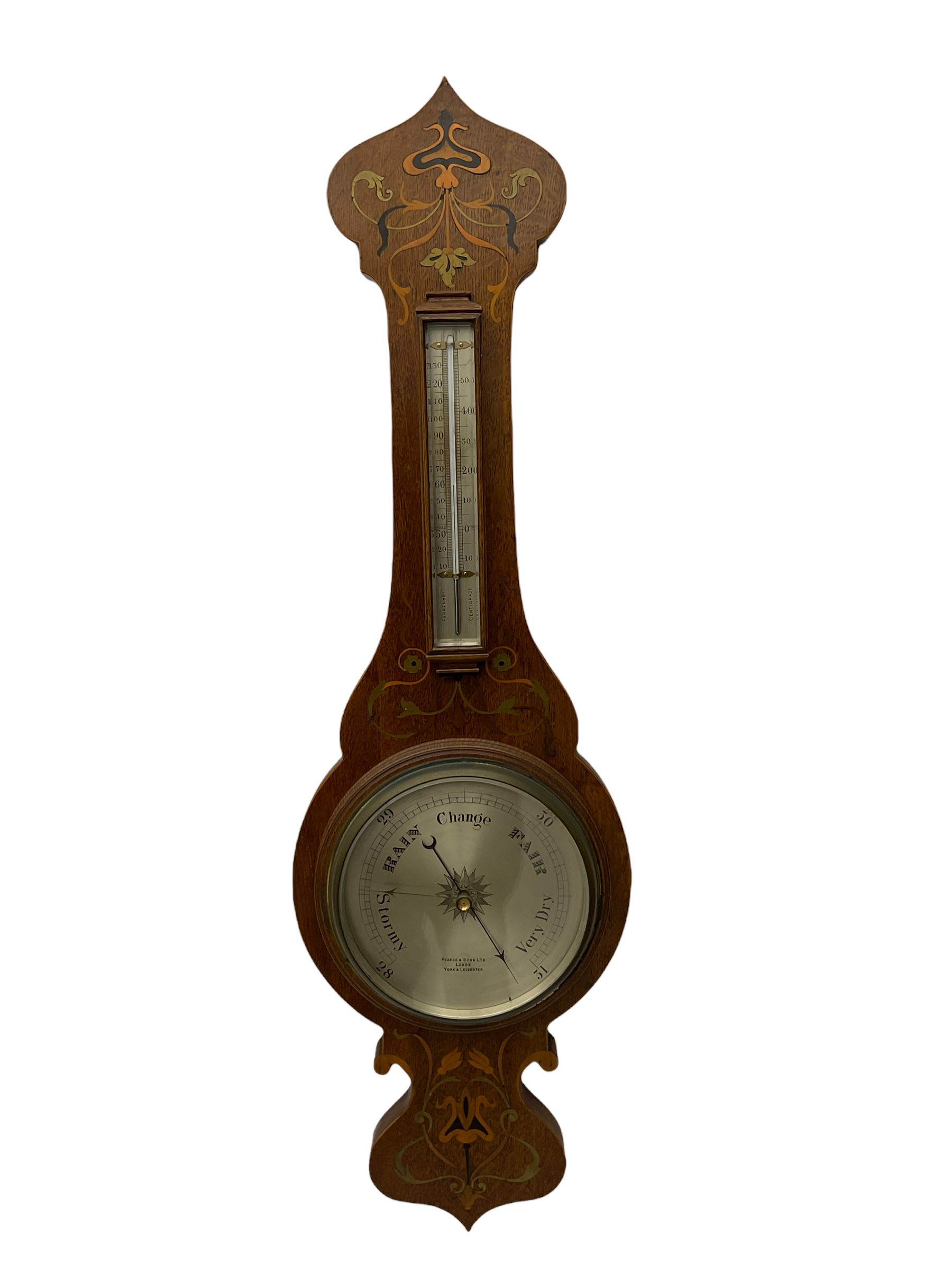 An early 20th century oak cased aneroid barometer in a decorative form