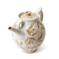 John Egerton (c1945-2024): studio pottery teapot, decorated with foliage and flowers on a cream ground, with impressed ammonites to the handle and spout, marked beneath, H28cm