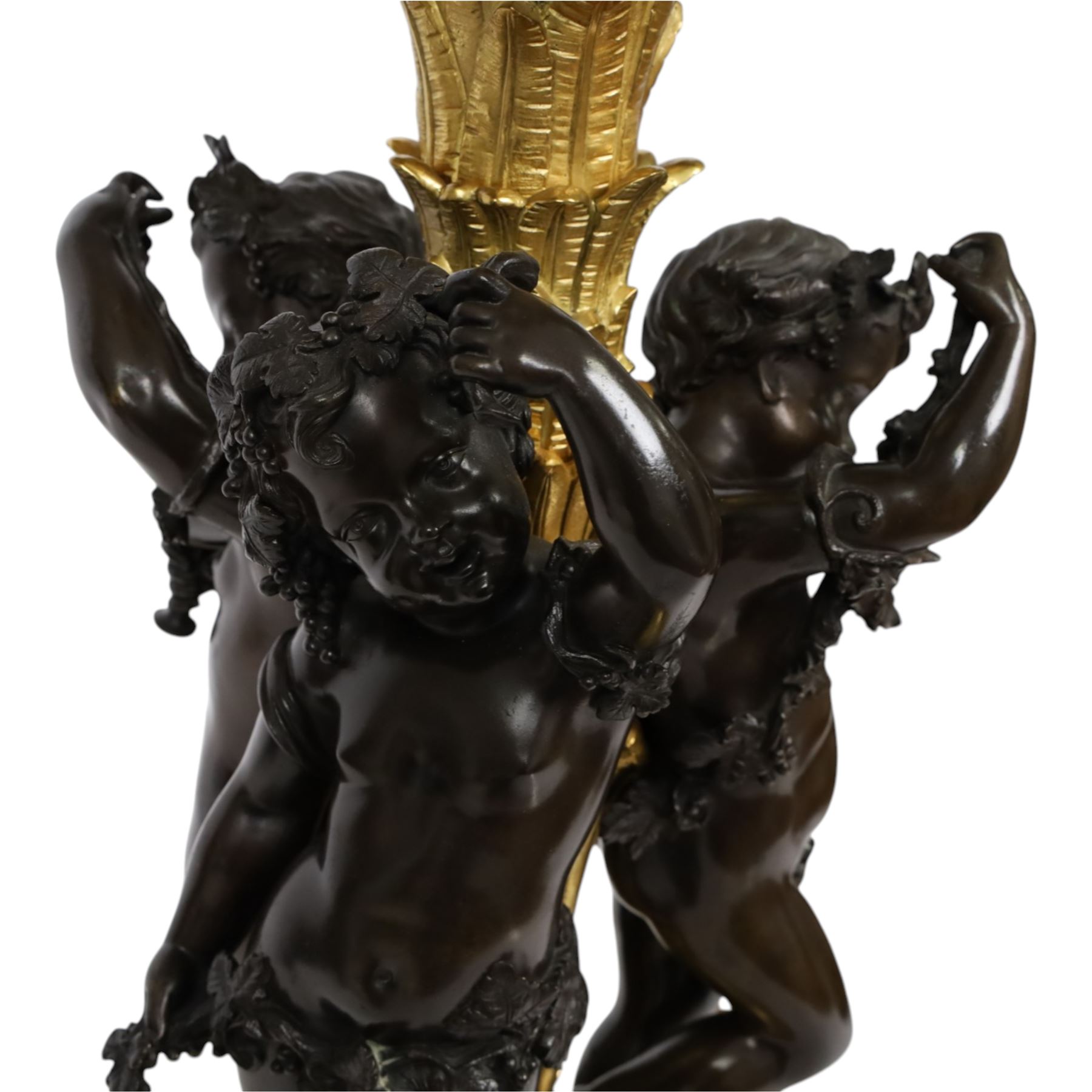 Louis XVI style gilt table lamp, the central column decorated with acanthus leaves, surrounded with three putti with vine leaf crowns, upon a circular base adorned with grape and vines, with shade, H64cm