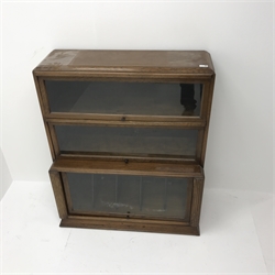  Early 20th century oak stacking library bookcase, three up and over glazed doors enclosing two shelves and single sectional unit, plinth base, W93cm, H108cm, D39cm  