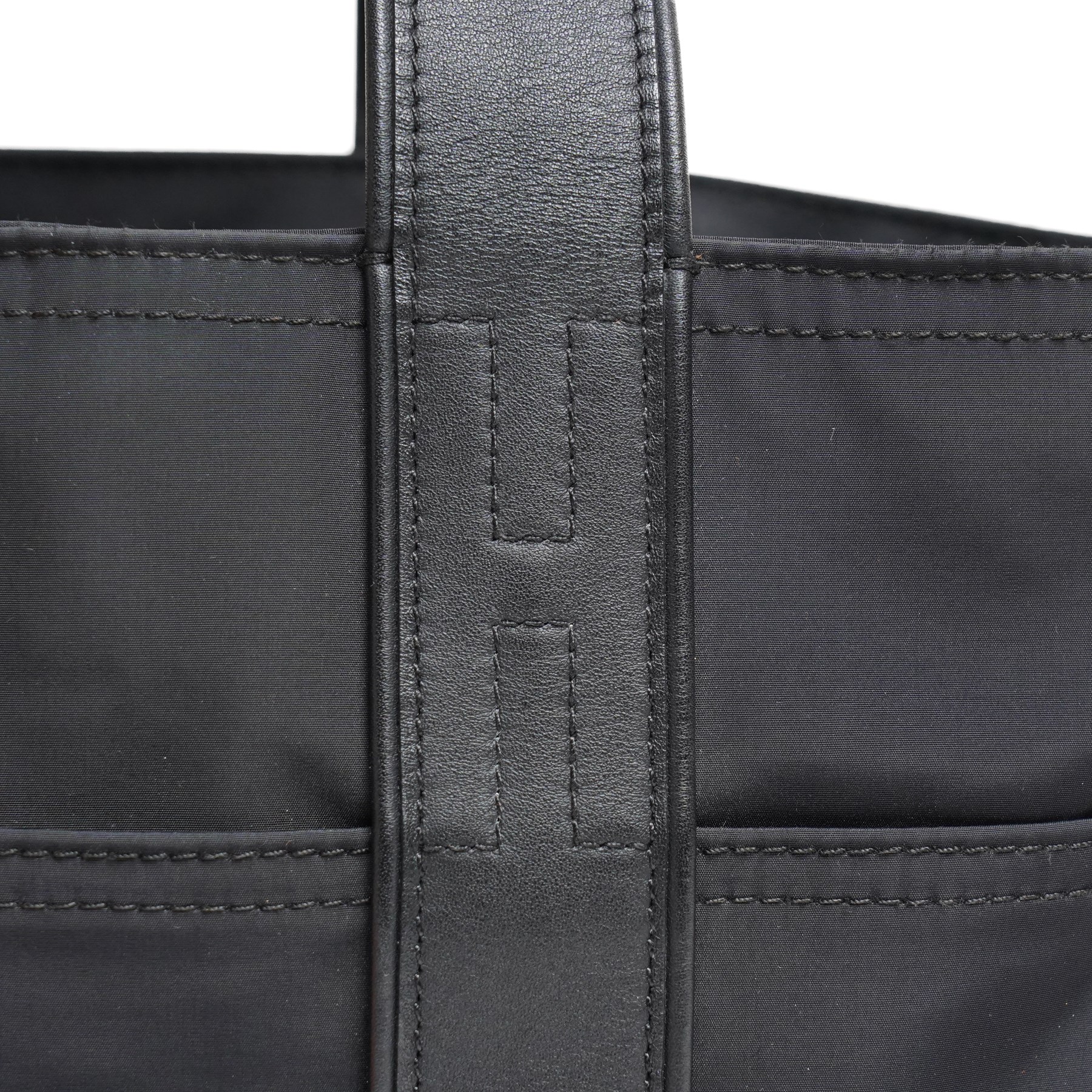 Hermès - Acapulco PM tote bag in black Toile Chevron canvas with black leather trim, the rectangular body with twin flat handles incorporating stitched H details, top zip fastening and eight exterior slip pockets, opening to a black nylon-lined interior with zip pocket, palladium-tone hardware, stamped Hermès Paris Made in France, with original Hermes dust bag