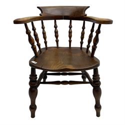 Early 20th century elm and beech smoker's bow elbow chair, shaped back and arms with scrolled terminals, on a series of turned spindle supports, dished seat on turned supports joined by double H stretcher