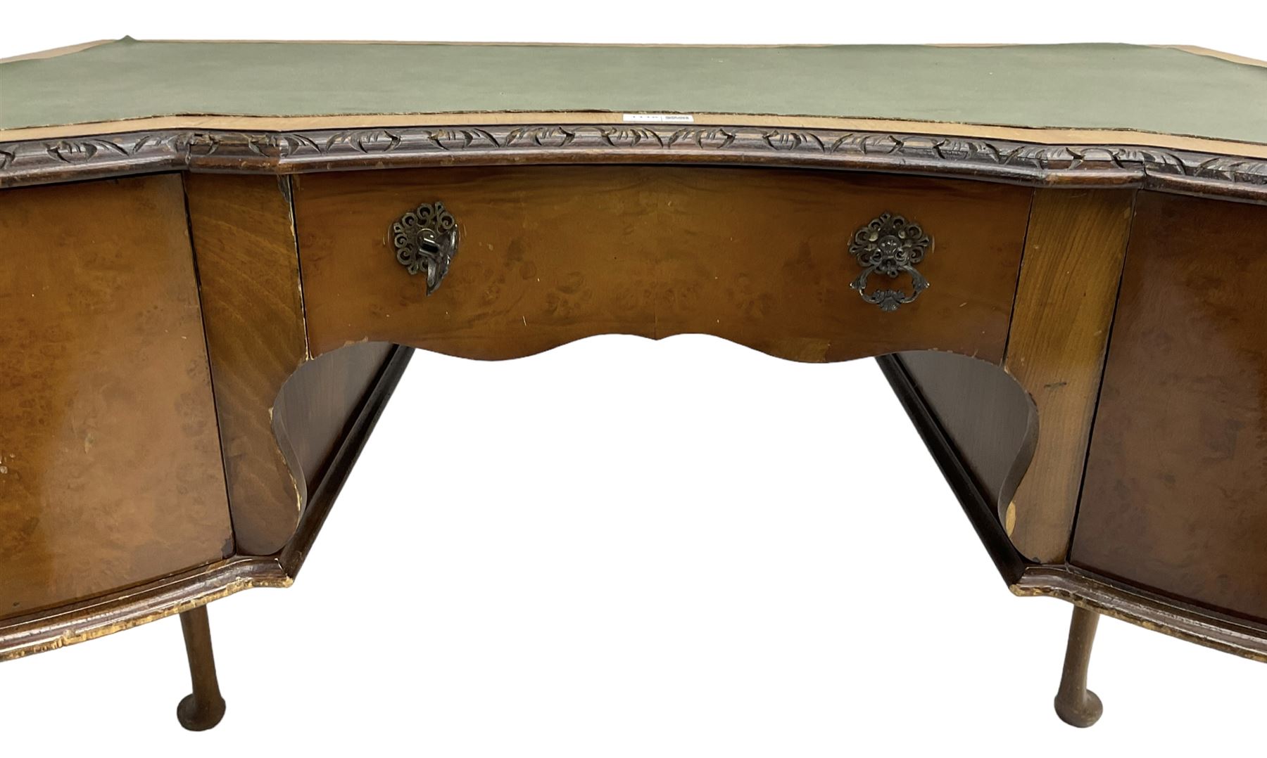 Early 20th century Queen Anne design walnut writing desk, reverse bow-front with inset green leather writing surface and foliate carved edge, fitted with three drawers, raised on cabriole supports