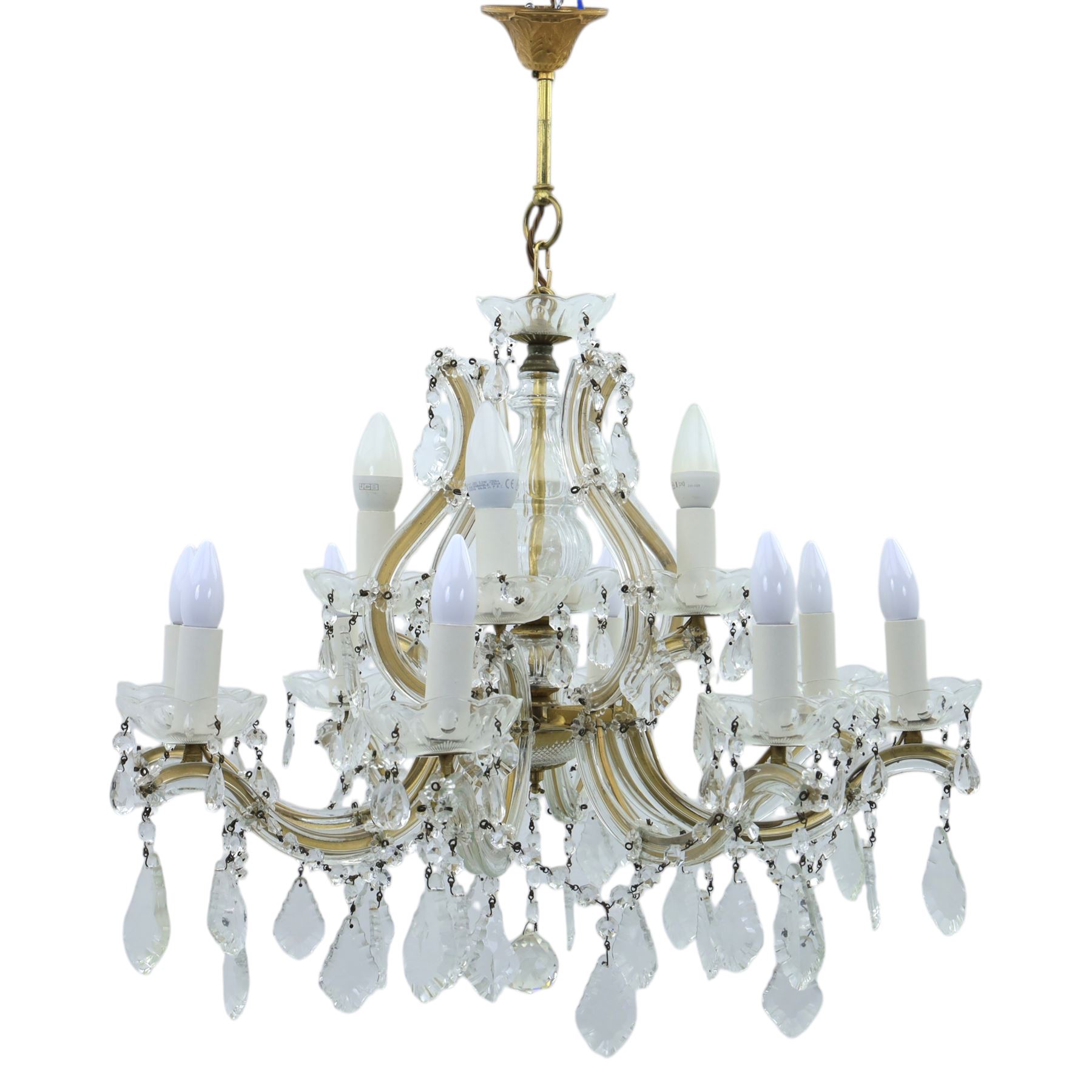 20th century Maria Theresa style twelve branch chandelier, gilt metal frame with scrolling arms clad in moulded glass, the central baluster stem issuing twelve candle sconces with glass drip pans, hung with faceted pendants and swags of cut glass beads 