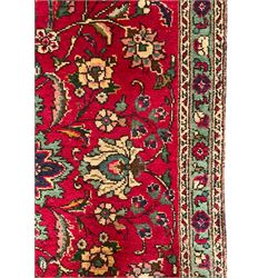 Persian Tabriz red ground rug, all-over interlacing floral design, central medallion decorated with stylised plant motifs, three narrow border bands, the main band decorated with repeating flower head motifs