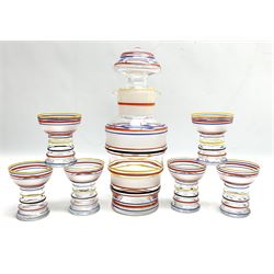 Mid 20th century Art Deco style cocktail bar set, decorated with bands of red, blue, yellow and black stripes, comprising shaker/decanter with stopper and two spouts and six glasses of shaped form