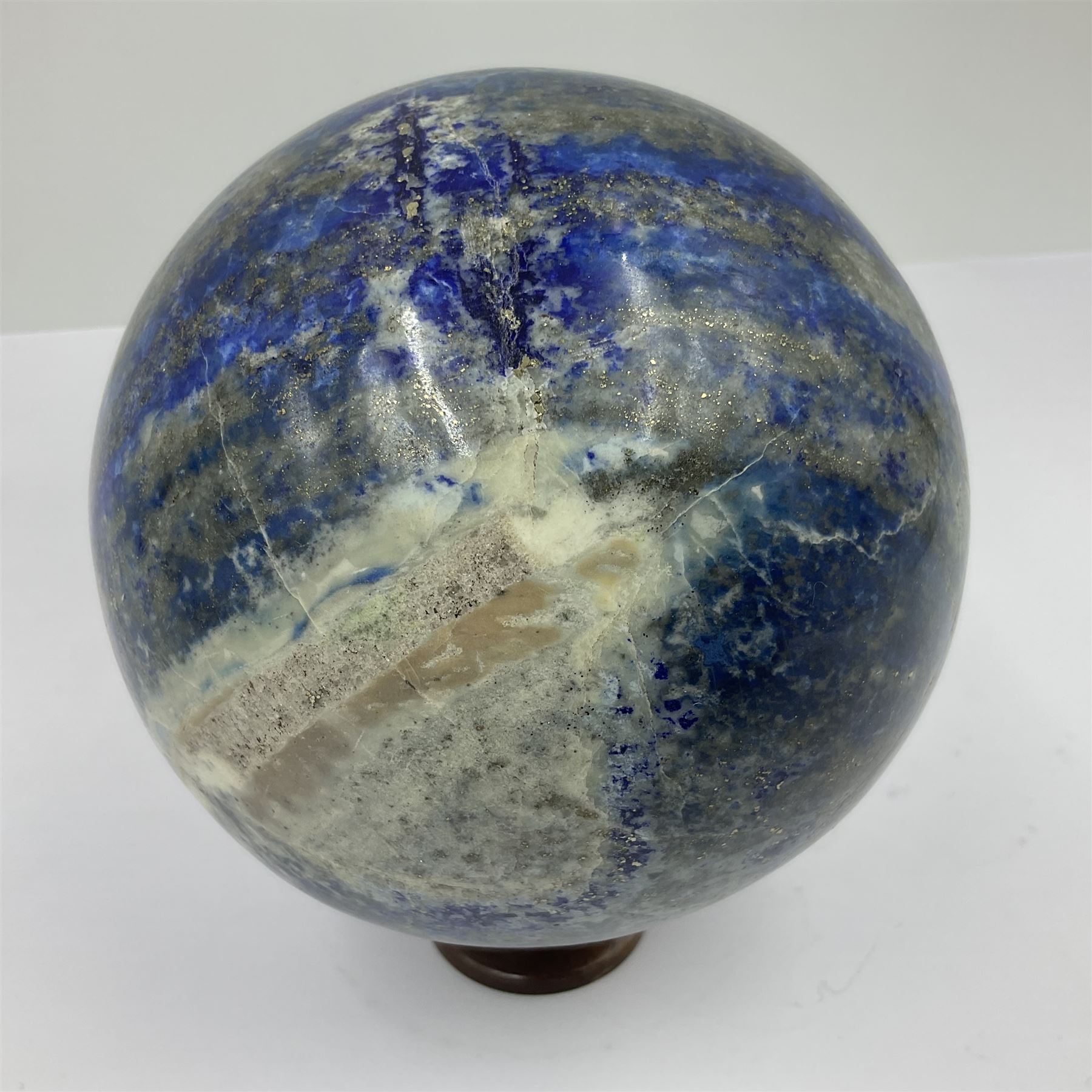 Lapis lazuli sphere upon a carved wooden base 
