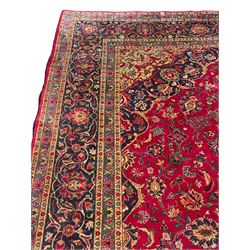 Persian Kashan carpet, red ground field decorated all-over with stylised floral motifs and interlacing branch, floral design central medallion and spandrels, the border decorated with plant motifs and scrolls