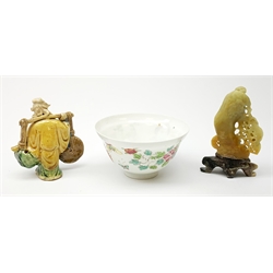 Japanese porcelain bowl enamelled with a fan shaped panel of a geisha, flowers and butterflies D10cm; Chinese soapstone carving of squirrels playing on a tree trunk; and Chinese glazed stoneware figure of a man carrying possessions on a yoke (3)