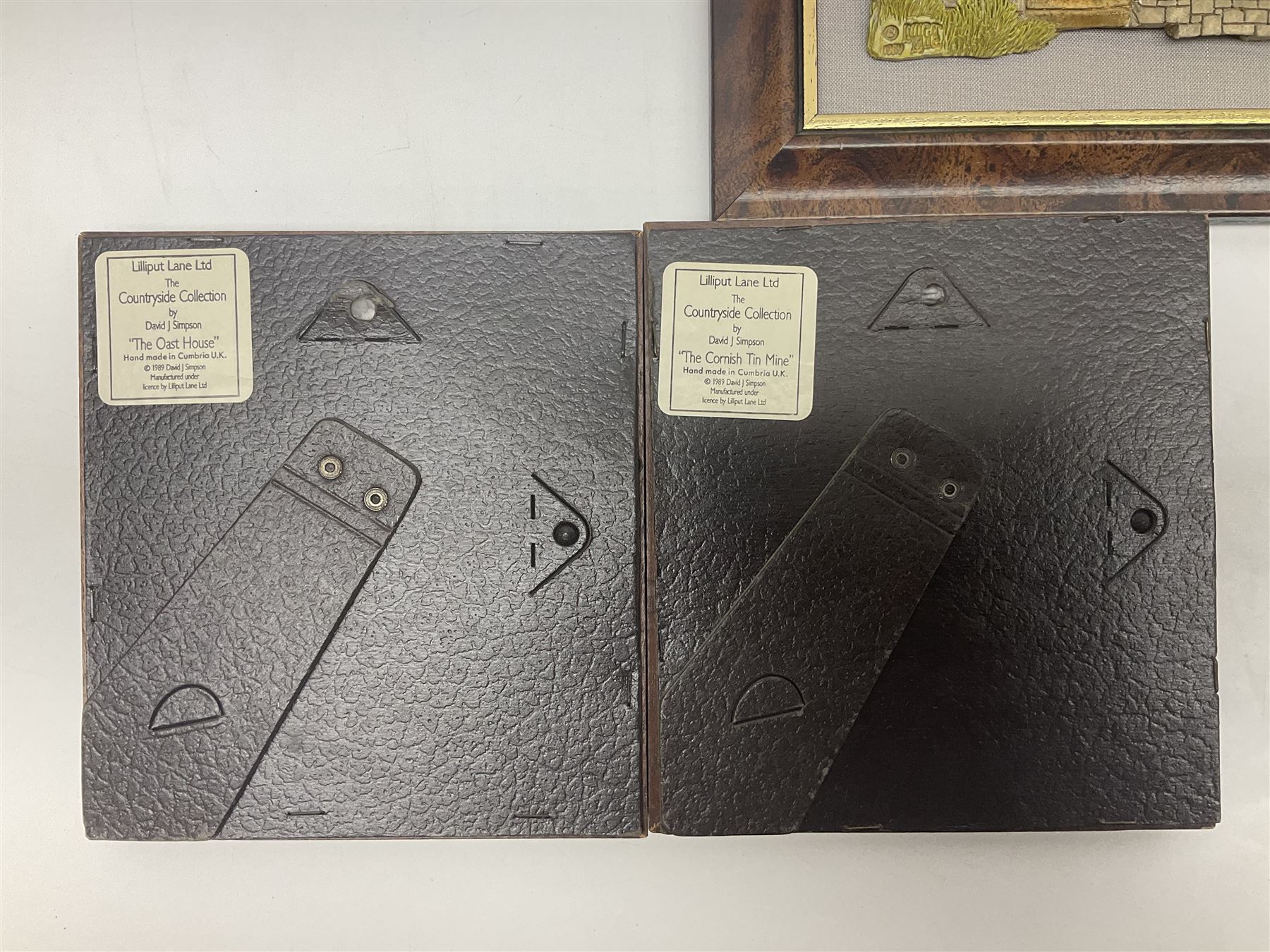 Nine Lilliput Lane framed wall plaques, including Fell View, Battleview, Catslide Cottage, Ashdown Hall and Shannon's Bank, together with three smaller circular framed Lilliput Lane plaques