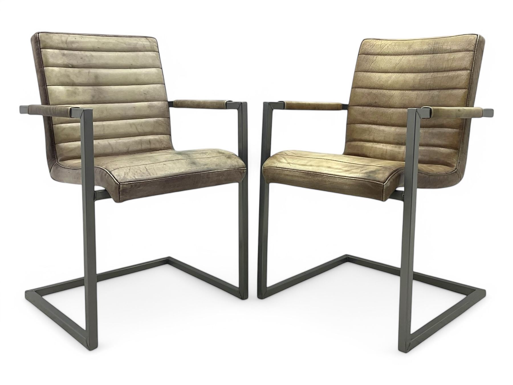 Pair of contemporary industrial style armchairs, each featuring a squared steel cantilever frame with upholstered arms, the seat and back finished in channel-stitched distressed tan faux leather