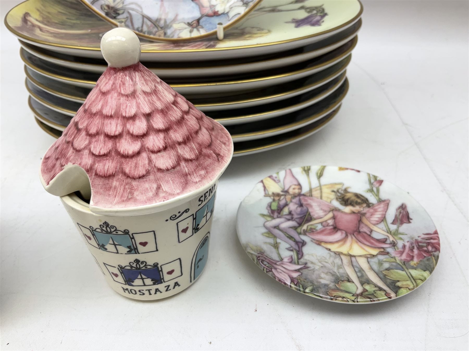 Royal Worcester Flower Fairies oval collectors plates, Goebel mustard pot, two Danbury Mint Fairy Tale bells, and pair of Hutschenreuther candlesticks decorated with scenes of Puss in Boots