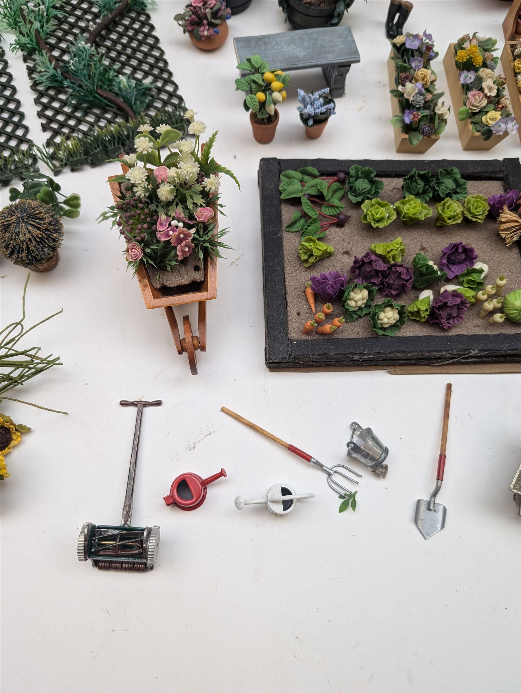 1:12 scale dolls house allotment and garden accessories, including wooden shed on a stone effect base, two vegetable patches, terracotta plant pots with flowers and foliage, stone effect plant pots, other planters, loose sunflowers, scarecrow, rabbit hutch, garden tools, fencing panels, etc 