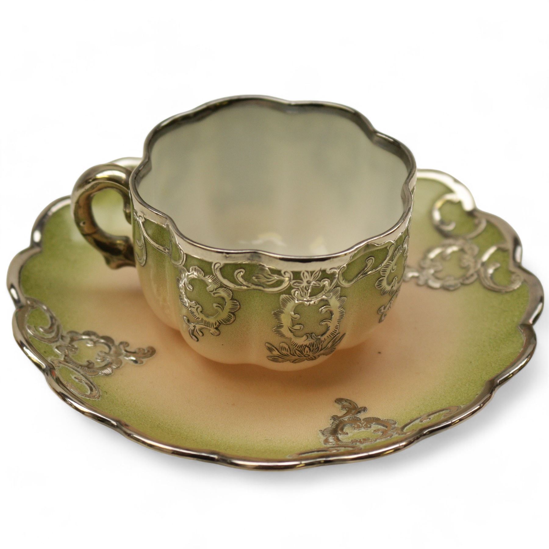 Three Pirkenhammer cups and saucers, two decorated with gilt birds in foliage on an ivory ground, the other with butterflies and foliate sprigs together with three  continental cups and saucers decorated with silver overlay 