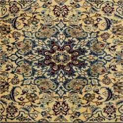 Central Persian fine Nain hand-knotted rug, ivory ground, with a central shaped floral medallion with pendants, surrounded by scrolling foliate and floral motifs incorporating rosettes, palmettes and delicate vine work in blue, cream and beige tones, enclosed by blue spandrels and an ivory border with repeating palmettes and meandering vines, flanked by floral guard stripes, with cotton fringes