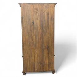 Pair of late 20th century Thai hardwood display cabinets, each with moulded cornice over twin glazed doors enclosing adjustable shelves, panelled cupboard doors below flanked by fluted columns, raised on bun feet