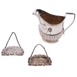 Edwardian silver cream jug with part fluted body, hallmarked Cooper Brothers & Sons Ltd, Birmingham 1908, together with two modern silver wine labels, detailed 'Sherry' and 'Port', hallmarked Francis Howard Ltd, Sheffield 1976 and 1977, approximate total weight 3.77 ozt (117.3 grams)