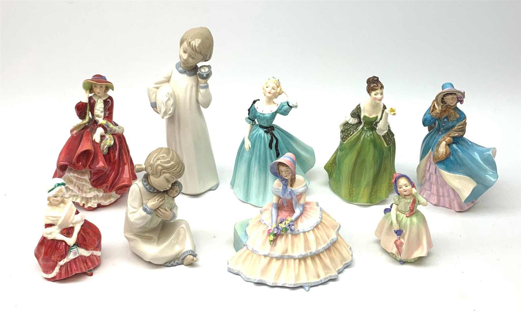 A group of seven Royal Doulton figurines, comprising Celeste HN2237, Day Dreams HN1731, Fleur HN2368, Top o' the Hill HN1834, Delphine HN2136 (a/f), Peggy HN2038, Babie HN1679, together with a Nao figurine, and a Zaphir figurine, (Spanish examples a/f). 