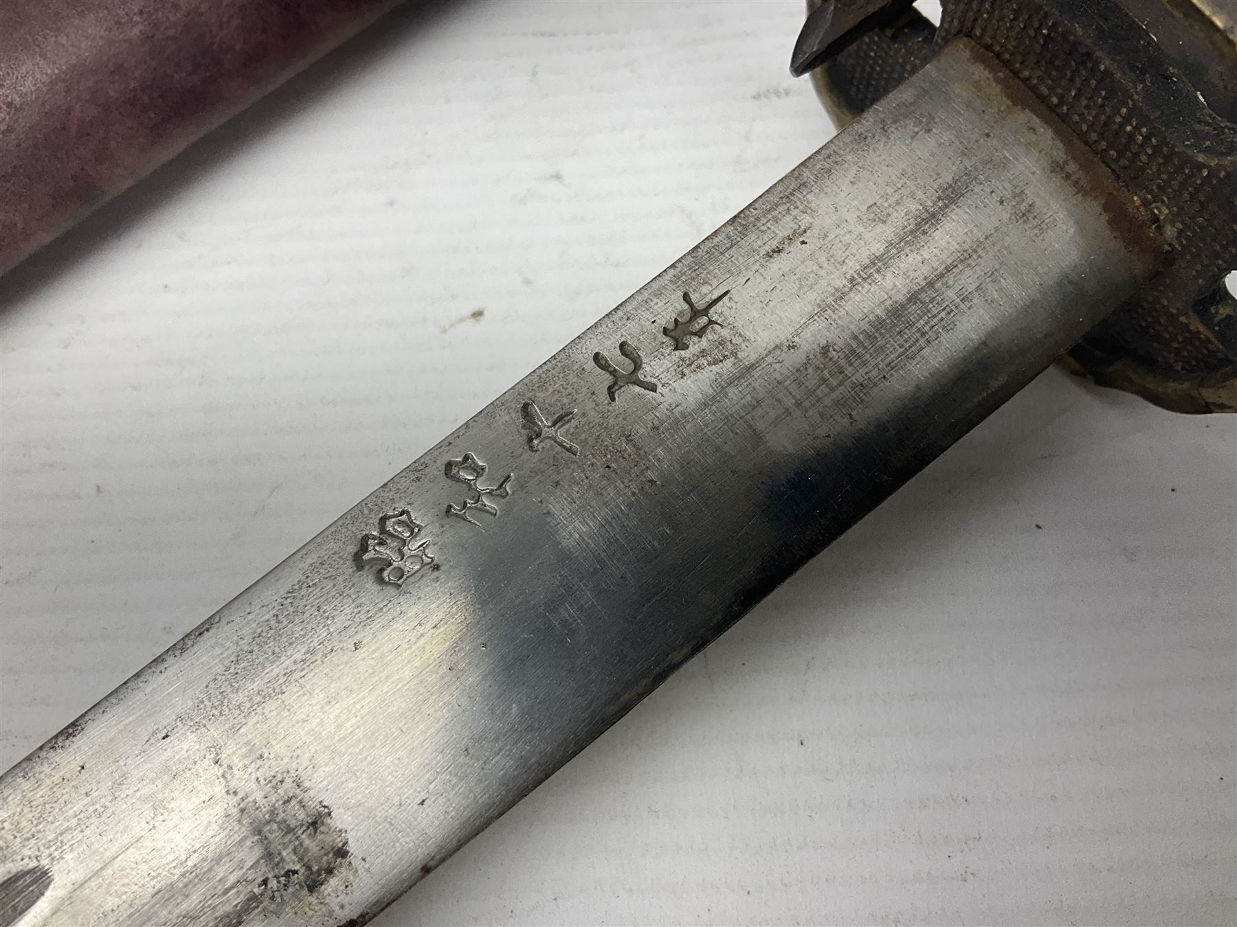 Copy of a WWII Japanese NCO sword, the 65cm slightly curving blade stamped with pseudo Japanese characters and cast brass simulated cord bound grip; in officer's leather bound field scabbard L97cm overall