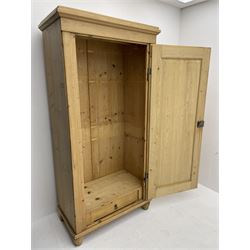 Solid pine single wardrobe, panelled door enclosing hanging rail above single drawer, shaped block supports 