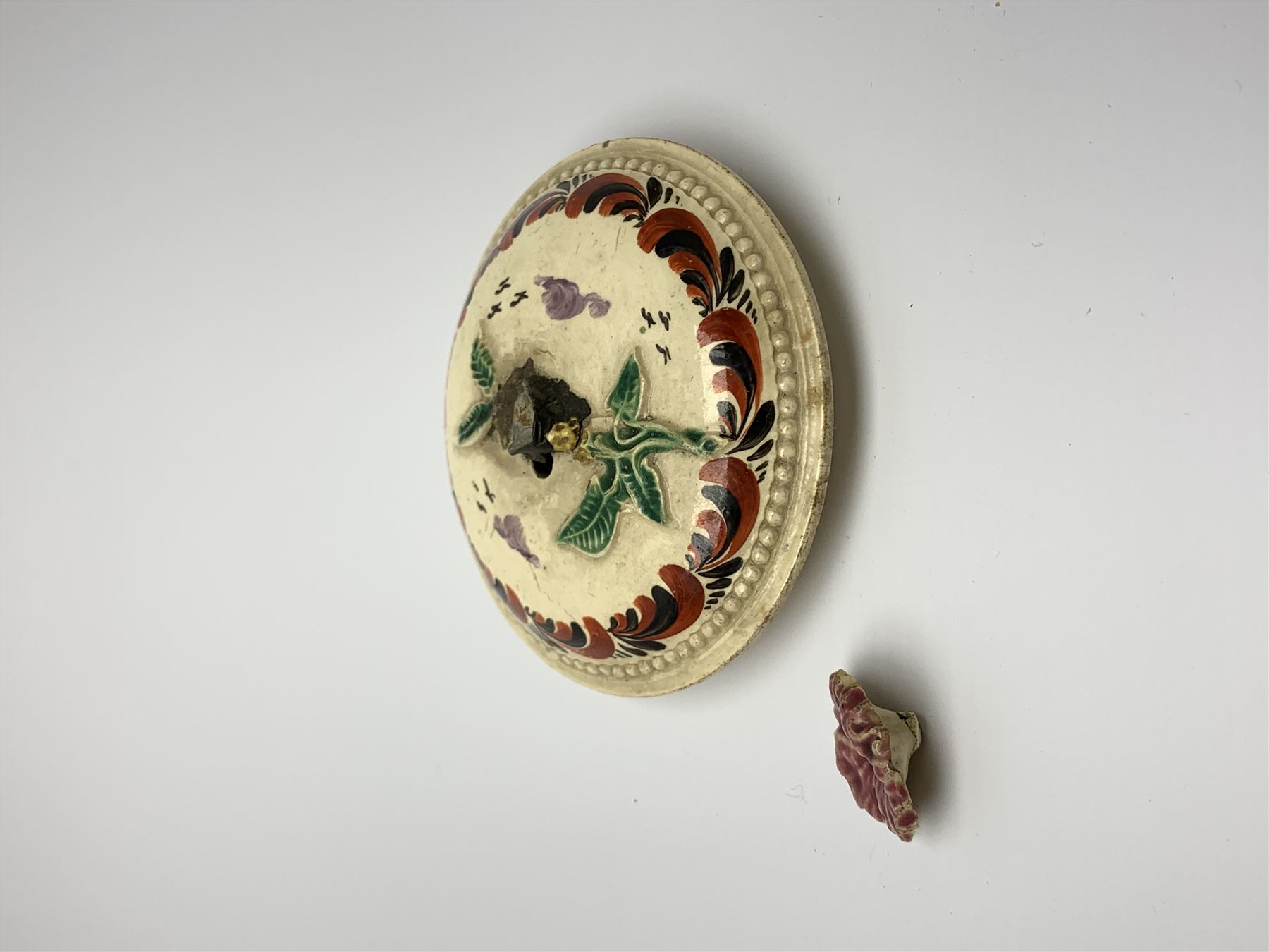 18th century creamware teapot, probably Leeds, with reeded entwined handle and floral finial to the cover, the body with hand painted polychrome decoration of figure to one side, and floral spray to the other, collectors paper label beneath inscribed Leeds Pottery, H11.5cm