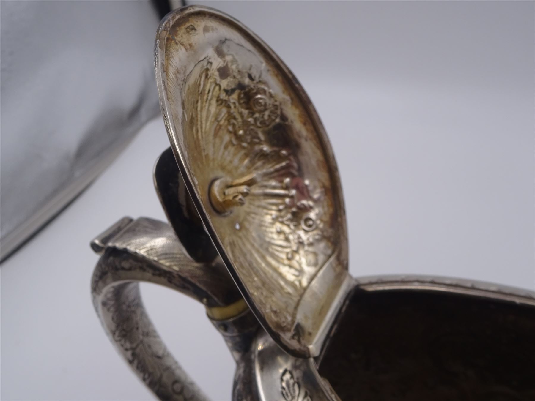 George III silver teapot, of oval form, with embossed foliate, floral and scroll decoration and engraved central cartouche, with acanthus capped C handle with ivory insulators, hallmarked John Emes, London 1807 This item has been registered for sale under Section 10 of the APHA Ivory Act
