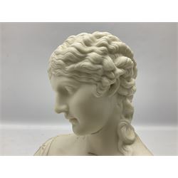 Two 20th century Parian ware female busts, the first modelled in the classical manner in draped fabric, emerging from a foliate border upon a tapering circular bust, the second modelled in a classical manner with foliate decoration in her hair upon a tapering circular bust, tallest example, H26cm