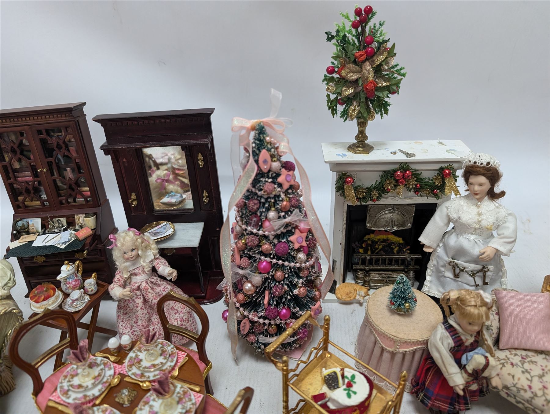Dolls house living room and ding room furniture, including sofa, chair, long case clock, Christmas trees, fireplace, dresser, chairs, tables, mirrors, seven figures and a collection of predominantly Christmas themed decorations, food, etc