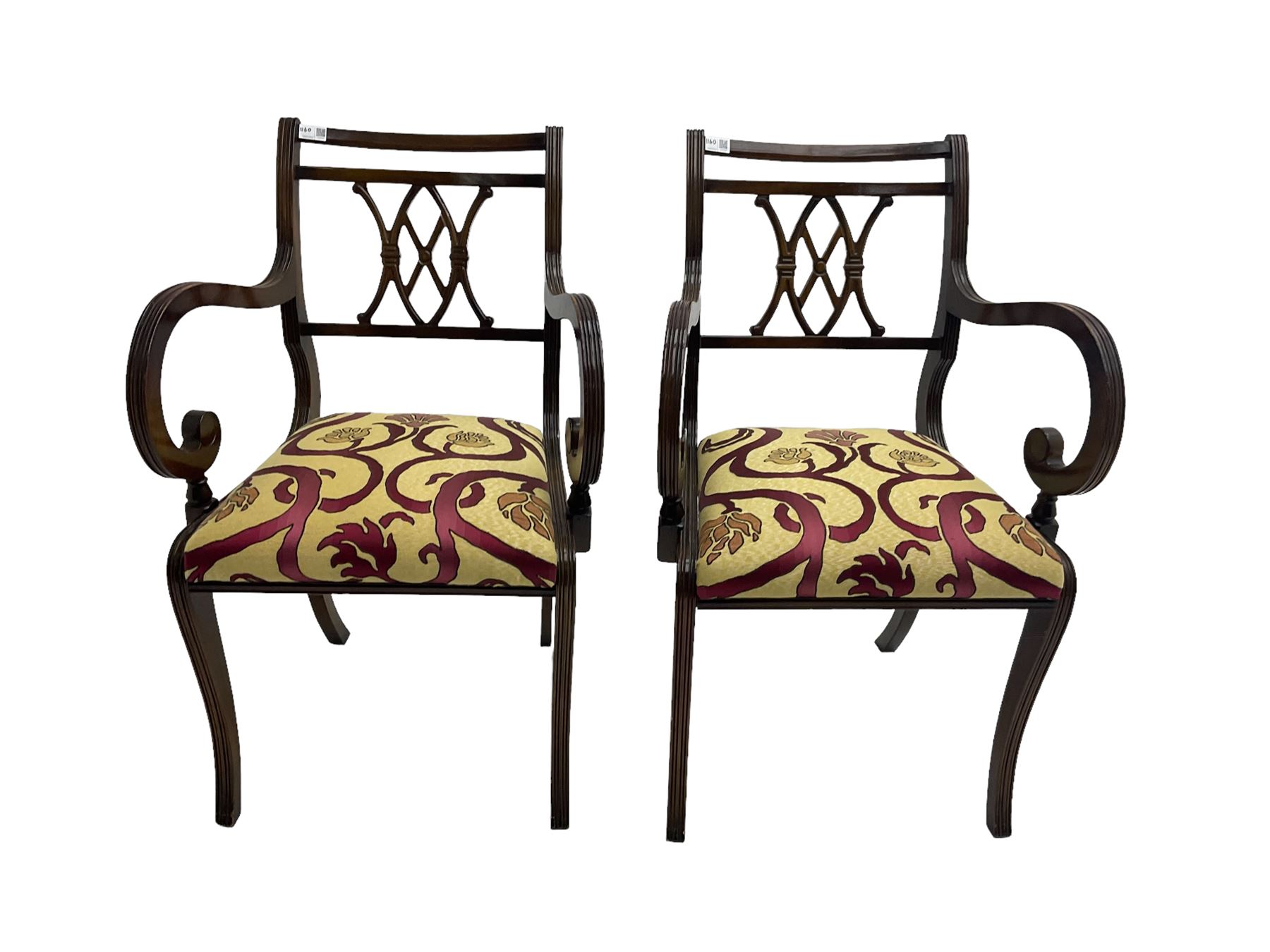 Regency design mahogany twin pedestal dining table, rectangular top with reeded edge, acanthus carved turned column terminating in reeded tripod base with hairy paw feet and castors (W172cm D92cm H75cm) and set eight (6+2) Regency design mahogany dining chairs, pierced back with scroll design, seat upholstered in patterned laurel green fabric, raised on reeded sabre supports (W48cm H88cm)