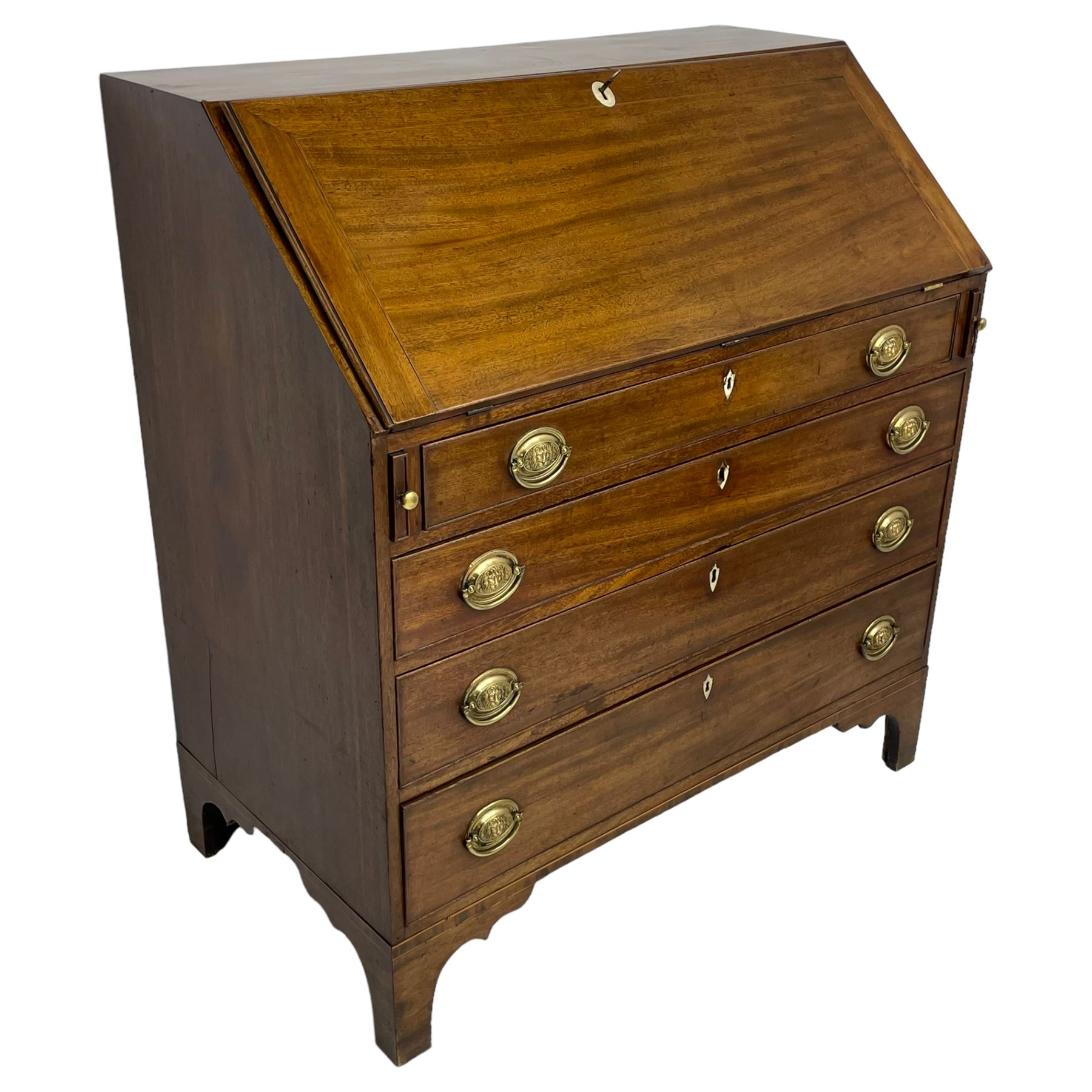 George III mahogany bureau, the fall-front banded and with boxwood stringing, enclosing fitted interior with pigeonholes and drawers surrounding a central cupboard with inlaid shell motif, the base with four graduating cock-beaded drawers, each with pressed brass handle plates with central lion masks and ivory escutcheons, on shaped bracket feet
This item has been registered for sale under Section 10 of the APHA Ivory Act