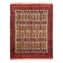 Turkaman red ground rug, the field divided into horizontal rows and decorated with geometric motifs, intricately pattern borders and end panels