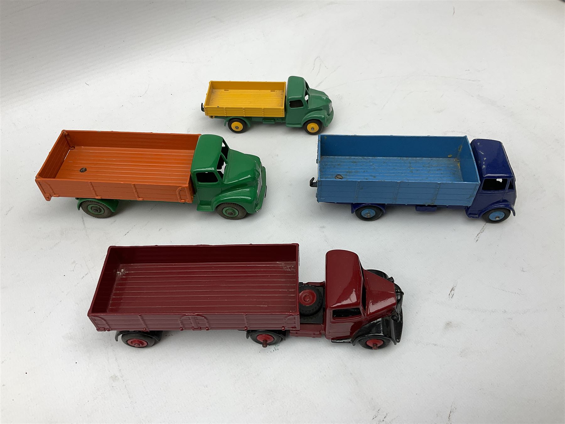Dinky - seven unboxed and playworn/repainted die-cast commercial vehicles comprising Bedford Articulated lorry, Leyland Comet, Big Bedford, Ford 800 tipper truck, Guy flatbed and planked flatbed lorries and Dodge tipper truck (7)