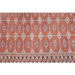 Afghan Turkoman crimson ground rug decorated with twin rows of hooked geometric guls within broad compartmented geometric borders (125cm x 201cm); Afghan Bokhara rug with repeated octagonal guls on a terracotta ground, enclosed by multiple geometric borders and patterned elem panels (120cm x 192cm) (2)