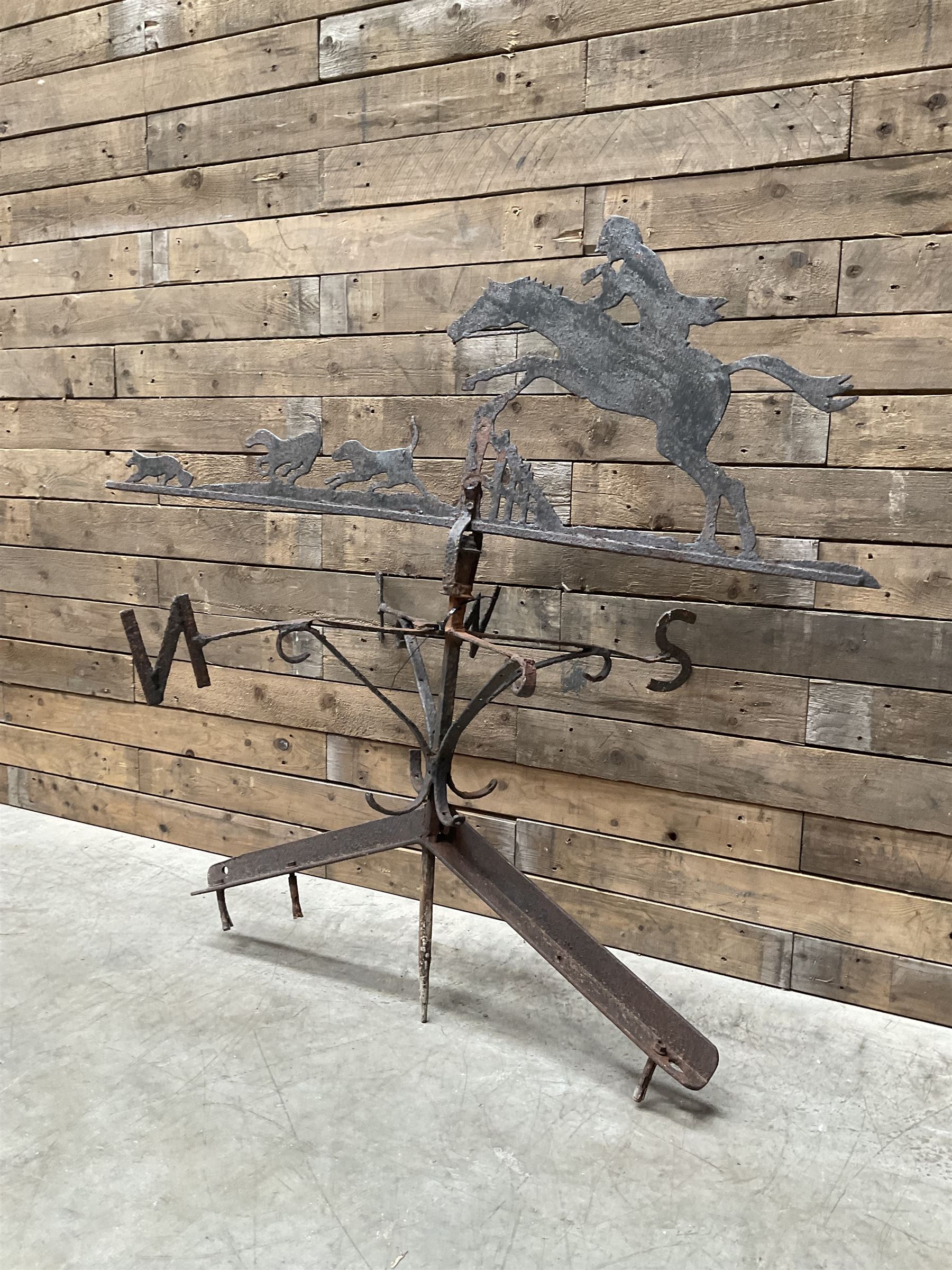 Black painted wrought iron weather-vane depicting hunting scene and compass points