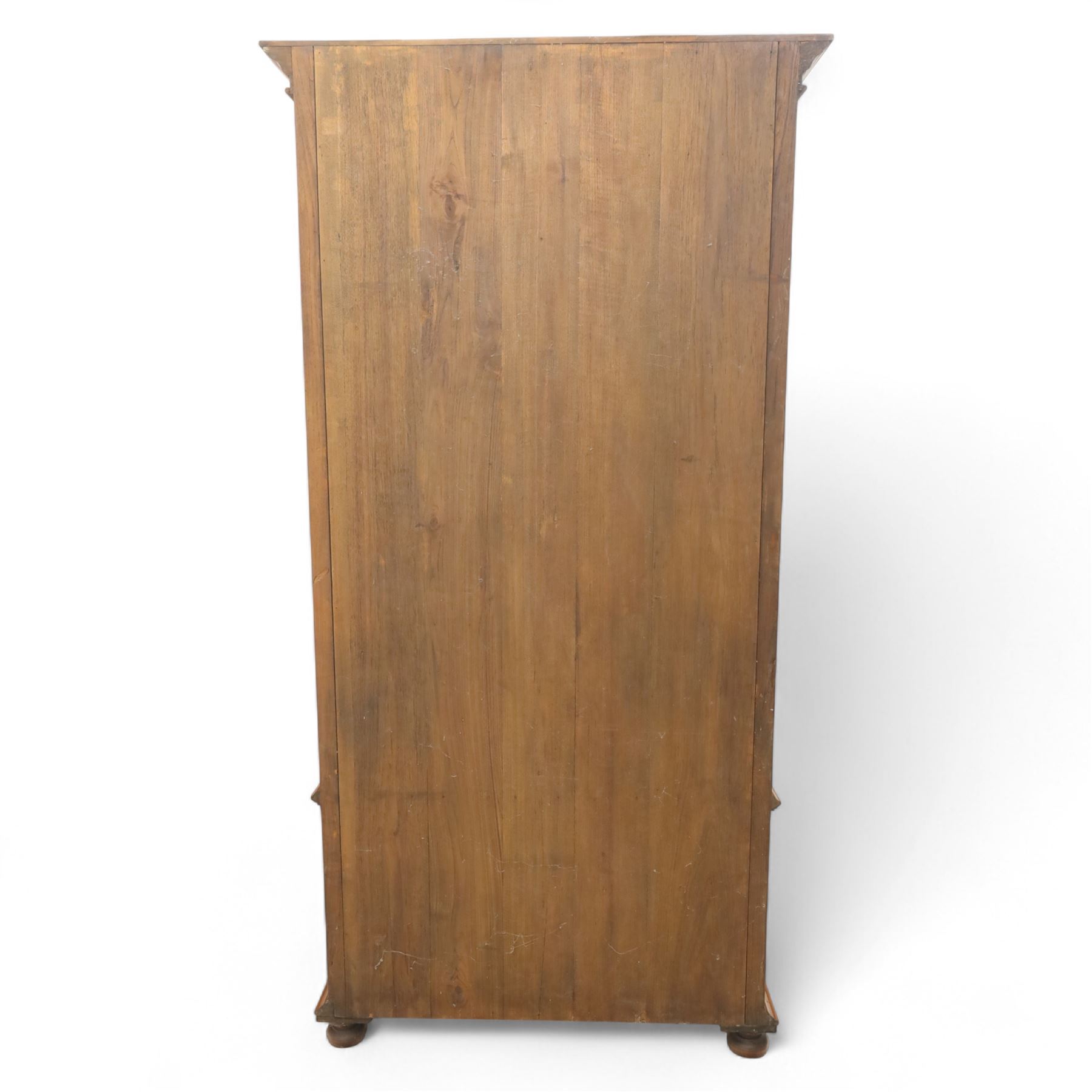 Pair of late 20th century Thai hardwood display cabinets, each with moulded cornice over twin glazed doors enclosing adjustable shelves, panelled cupboard doors below flanked by fluted columns, raised on bun feet