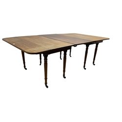 George III mahogany extending drop-leaf dining table, with additional leaf, rectangular top with rounded corners, raised on turned tapering supports with brass castors