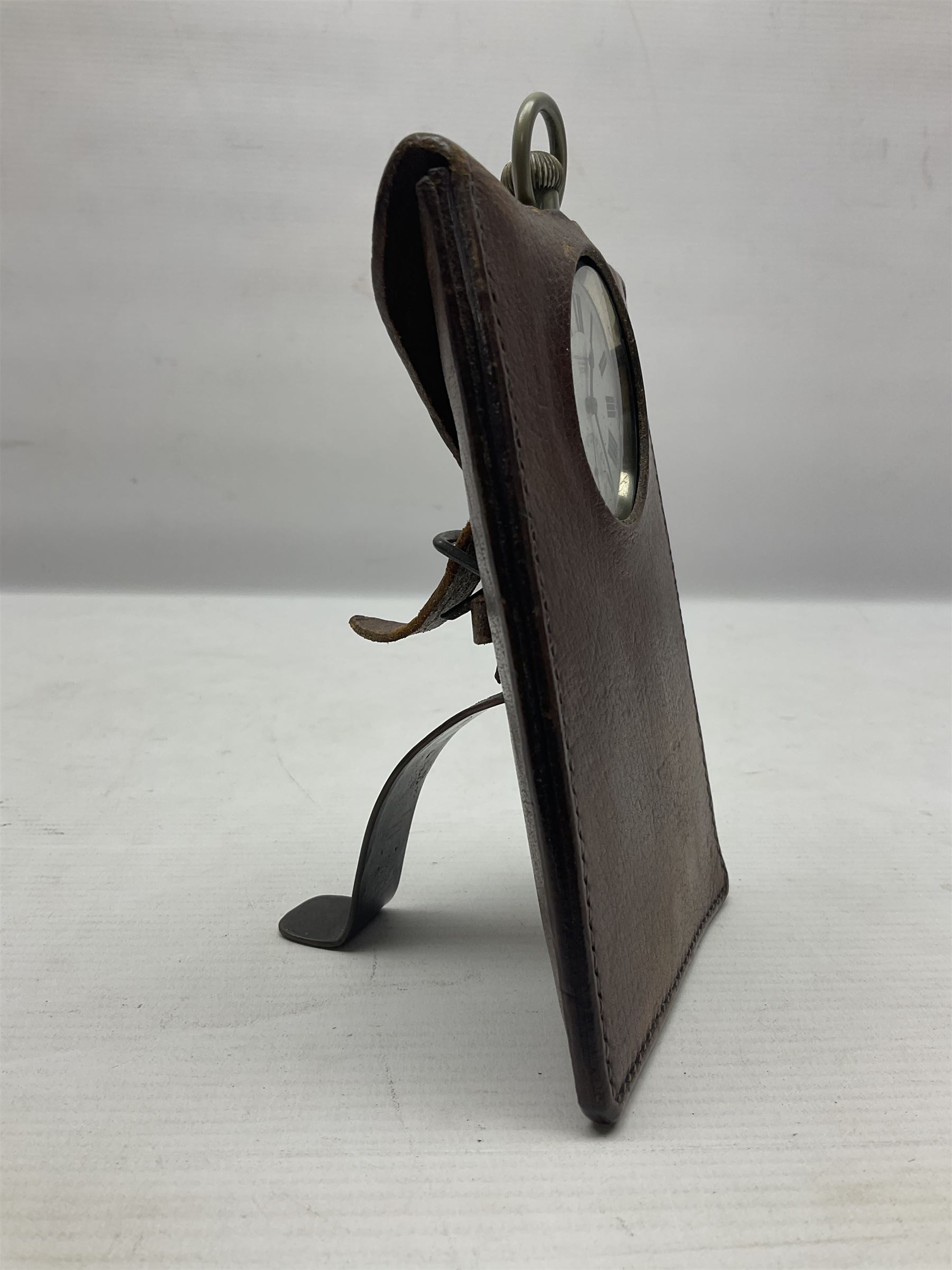 Early 20th century British Army officer's campaign clock in the form of a key-less wind nickel cased pocket watch with white dial, Roman numerals and subsidiary seconds dial, inscribed H. Williamson Ltd. London 9138F, the back with broad arrow and 9138F; in leather travelling case with dial aperture and brass easel support H14cm