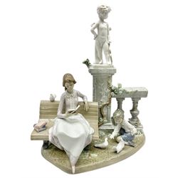 Lladro figure, Studying in the Park, modelled as a lady reading on a bench with child feeding fantail pigeons in front of a cherub statue upon square column, sculpted by Antonio Ramos, no 5425, year issued 1987, year retired 1991, H31cm