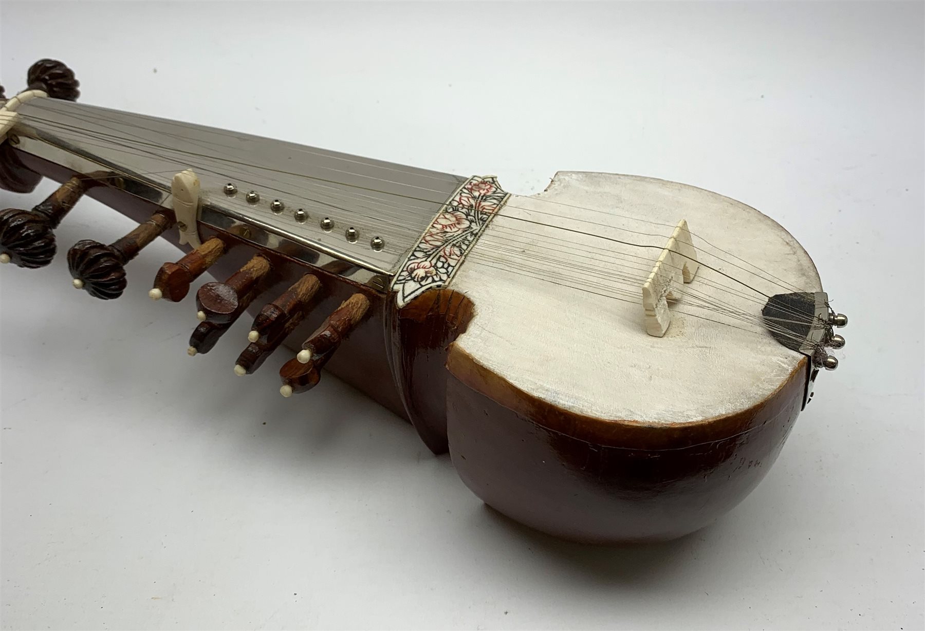 Indian sarangi multi-stringed instrument, the hardwood base with decorative bone inlay and mounts and metal covered fingerboard, L59cm