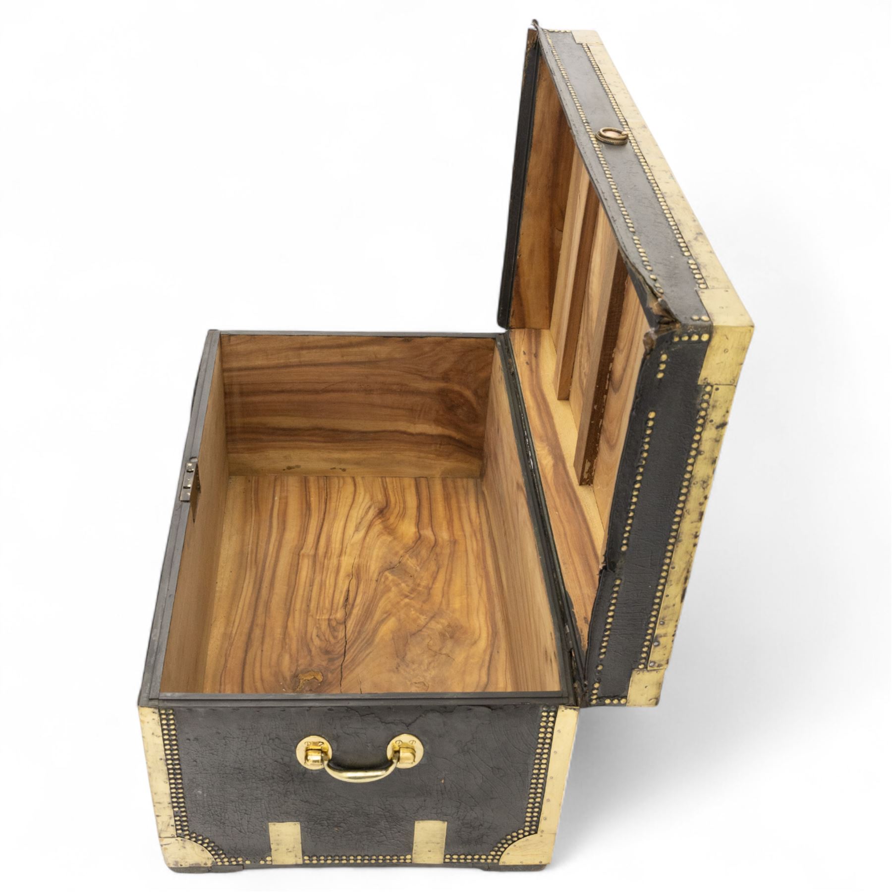 An early 19th-century Georgian brass-bound travelling trunk, leather-covered exterior with brass stud work decoration, front with central brass lock plate, hinged lid with camphor wood interior, external sides fitted with large brass carrying handles 