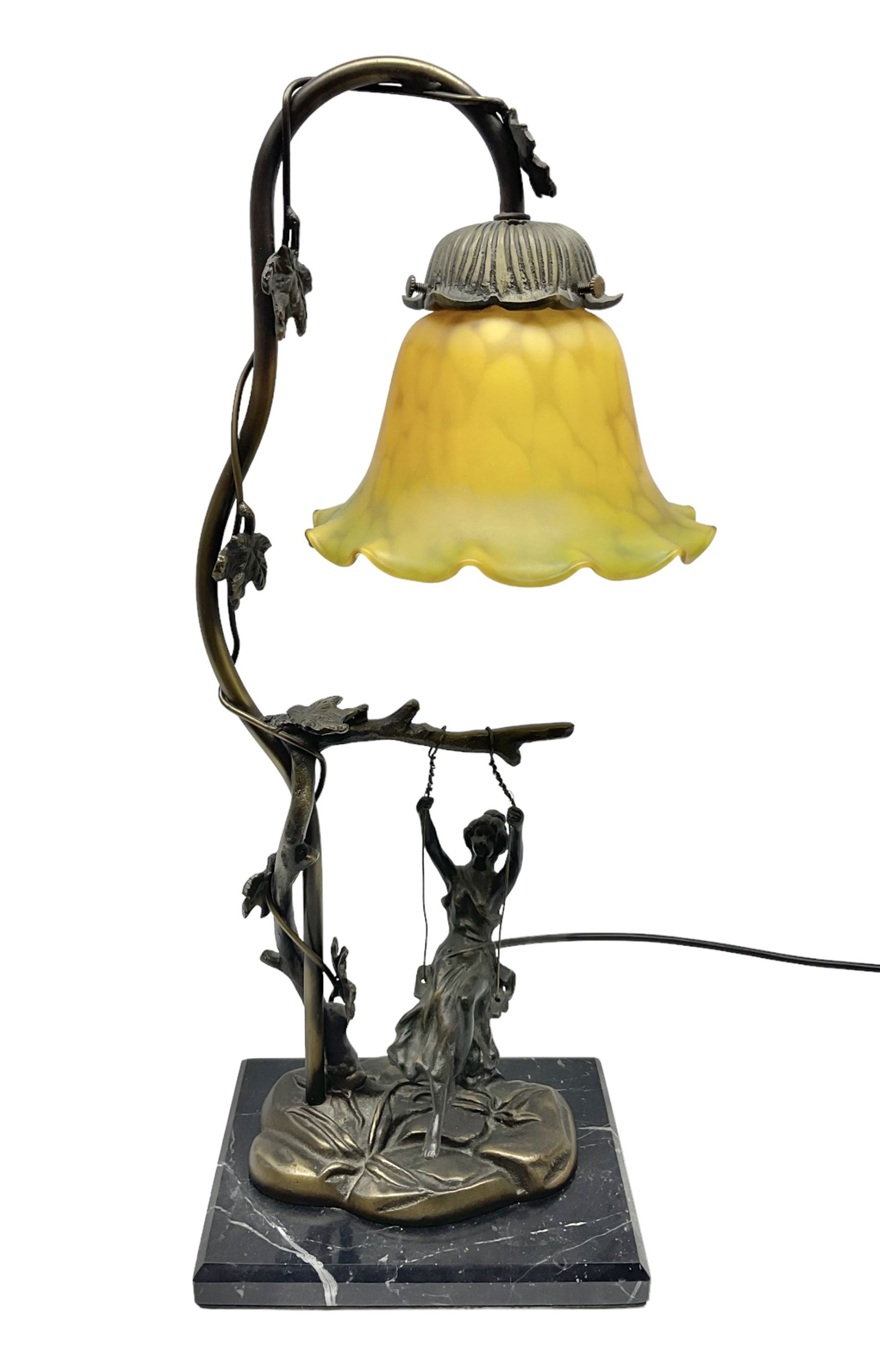 Art Nouveau style lamp in the form of a woman on a swing, with a green mottled shade, upon a marble base H52cm