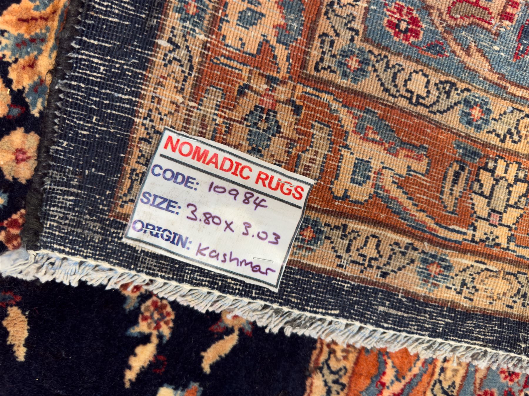 Northeastern Persian Meshed carpet, the deep navy field with a symmetrical floral arrangement of stylised flowerheads, palmettes and scrolling vines issuing from a central urn, enclosed by broad rust and blue borders of floral arabesques and lotus forms, from the region of Meshed