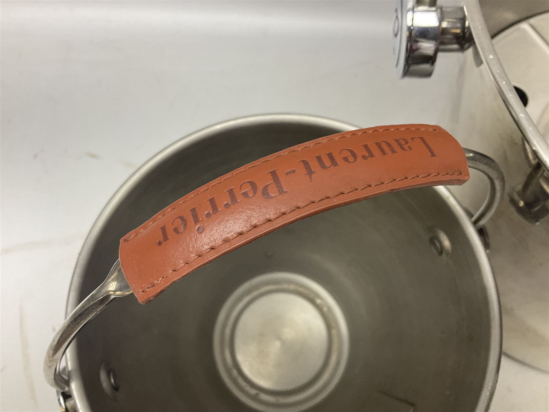 Stainless steel Laurent-Perrier champagne bucket, with engraved brass plaque and grip to swing handle, together with two matching smaller, largest D38cm (3)