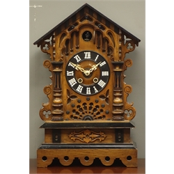  Late 19th/early 20th century Black Forest style cuckoo clock, arched architectural case, striking the hours and half on coil with two bellows, ebonised Roman chapter ring, H54cm  