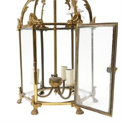 Three light hall lantern in metal and glass case, of hexagonal form, with classical decoration including a hand holding scroll handle, drop 72cm