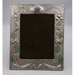 American Art Nouveau silver mounted photograph frame, of rectangular form, with oblique gadrooned rims, embossed iris flowers and vacant oval cartouche, interlaced with ribbons and green blue enamel, upon hobnail effect ground, with hardwood easel style support verso, stamped Sterling